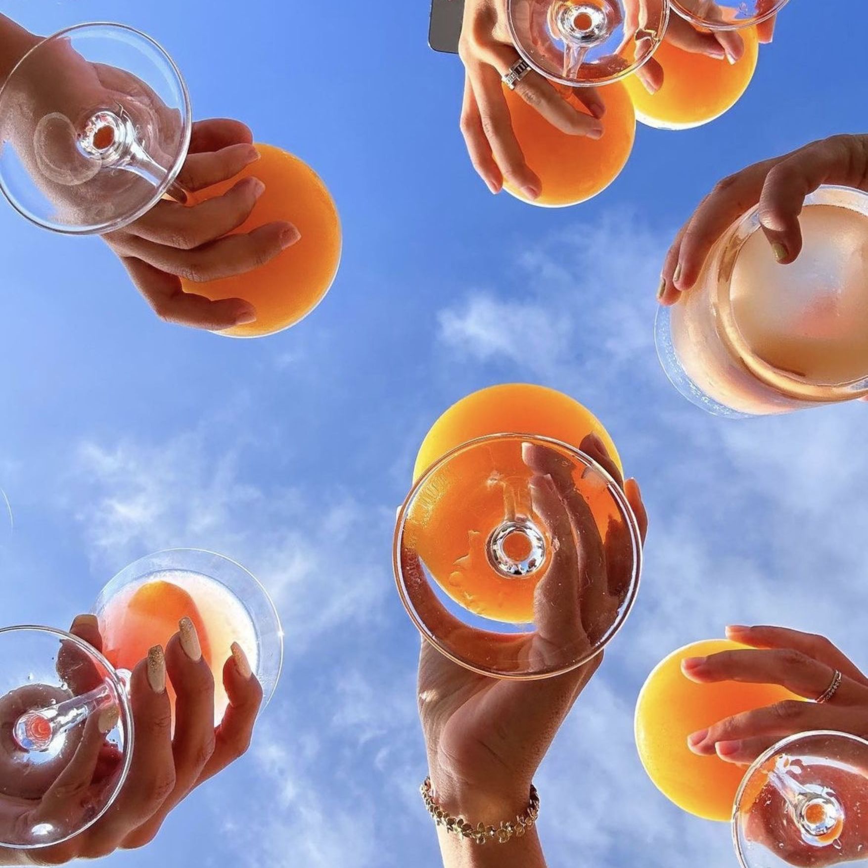 Cheers mit Spritz gegen den Himmel